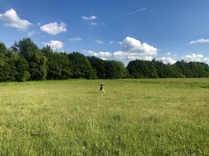 Man playing soccer on field against sky