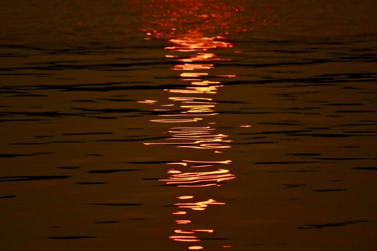 Full frame shot of rippled water against orange sky