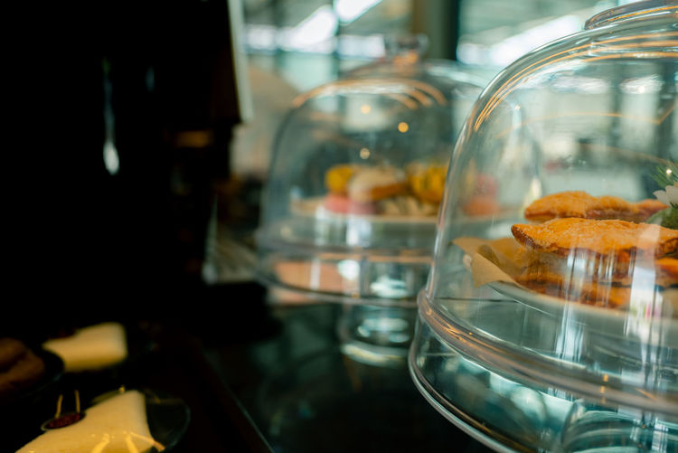 Pastry in cake glass stand display with cover dome in coffee shop or bakery shop.