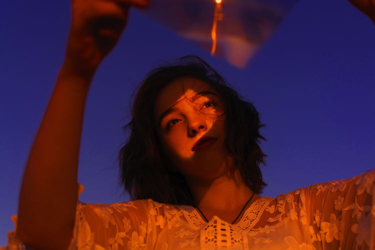 PORTRAIT OF BEAUTIFUL WOMAN LOOKING AWAY AGAINST SKY