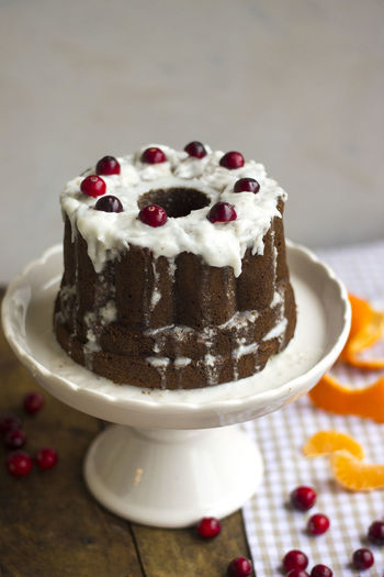 Cake with cranberries on stand over table