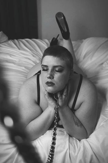 High angle view of woman tied with chain on bed