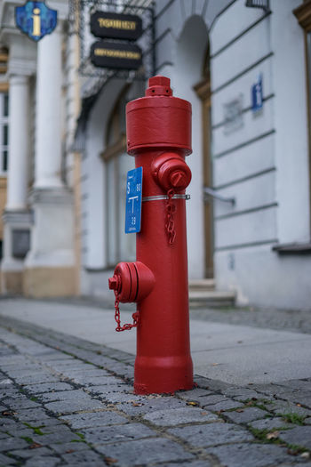 Red fire hydrant on footpath by building