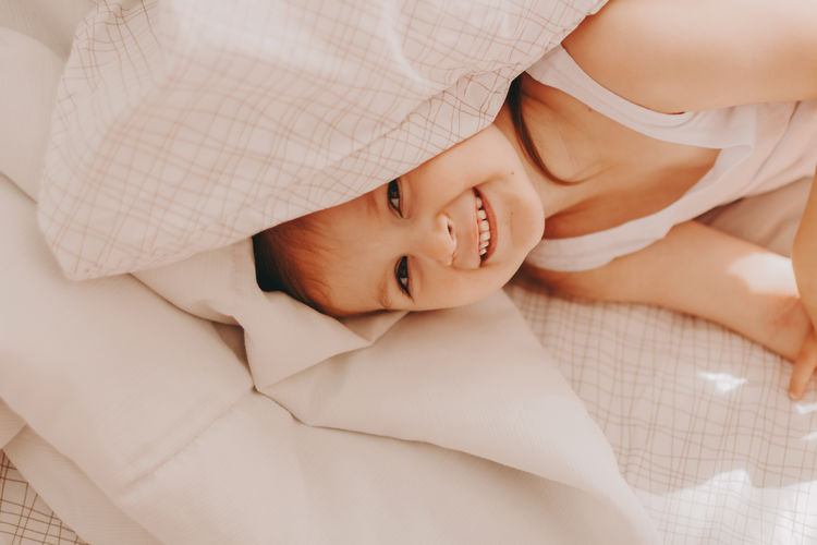 High angle view of cute baby sleeping on bed at home