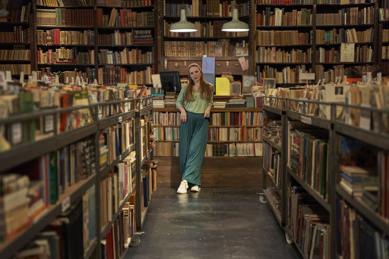 Rear view of woman standing in library
