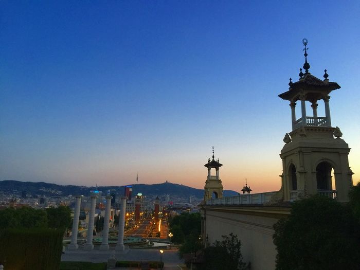 Columns by magic fountain of montjuic against blue sky during sunset
