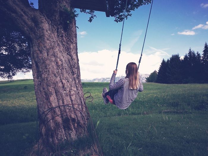 Woman sitting on swing at park