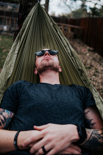 Vertical of man relaxing in hammock outside