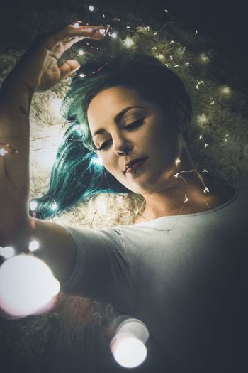 Portrait of young woman looking at illuminated christmas lights