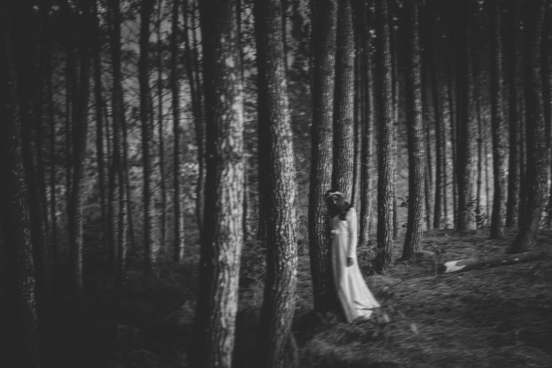 Woman leaning on tree in forest