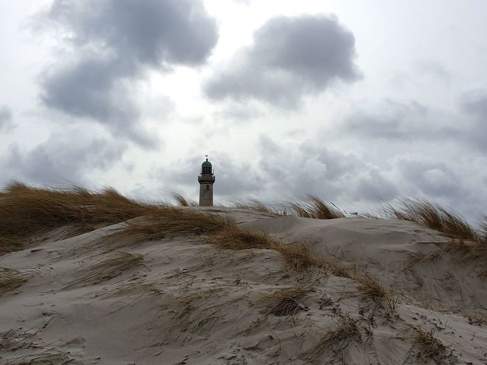 Lighthouse on land against sky