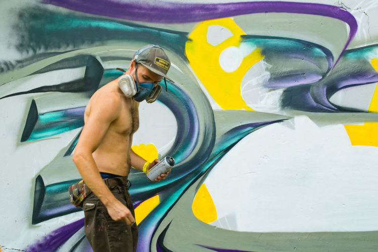 Man spray painting wall