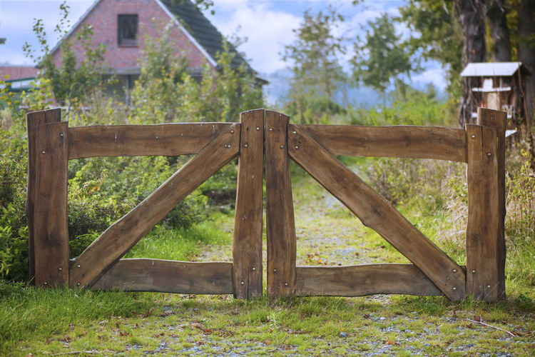 Frontal view of wooden entrance gate with a shallow depth of field in a rural setting in daylight