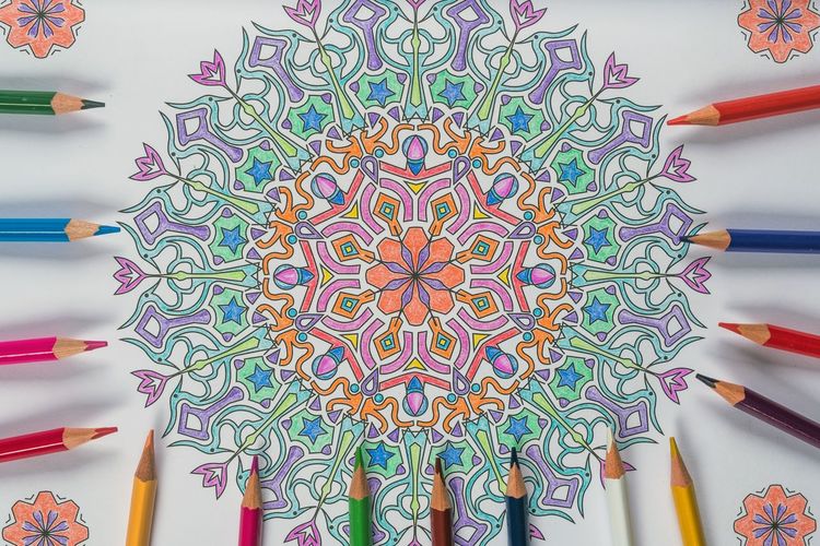 Close-up of colorful pencils by design on table