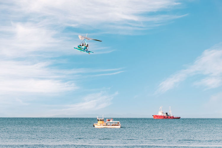 Side view of the sea with pleasure ships and a flying paraglider. fun entertainment at the seaside