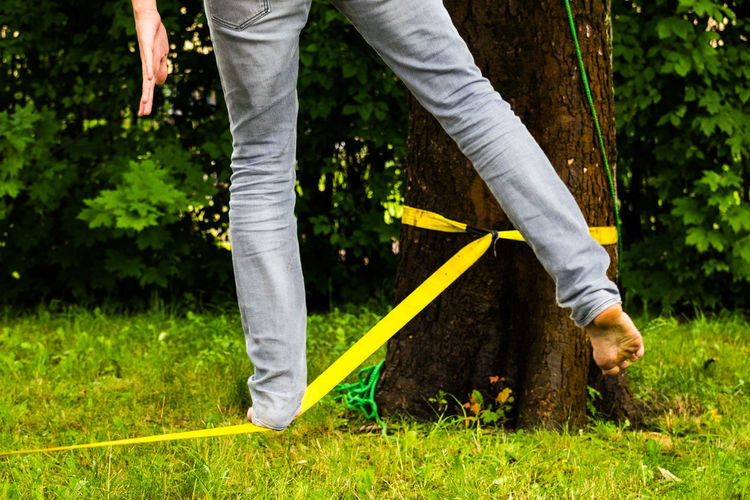 Low section of man standing on slackline