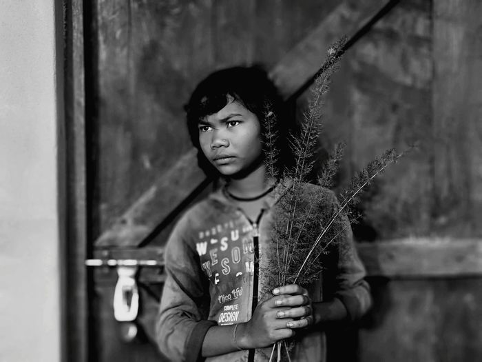 Portrait of young girl looking away against door