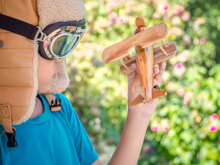 Close-up of boy holding wooden toy airplane