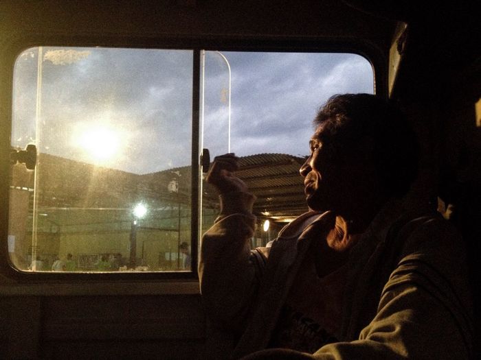 Close-up of man looking through window