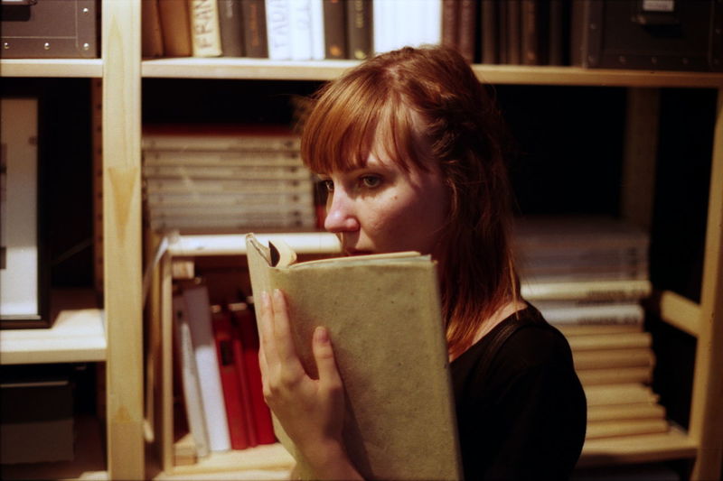 Young woman reading book in library