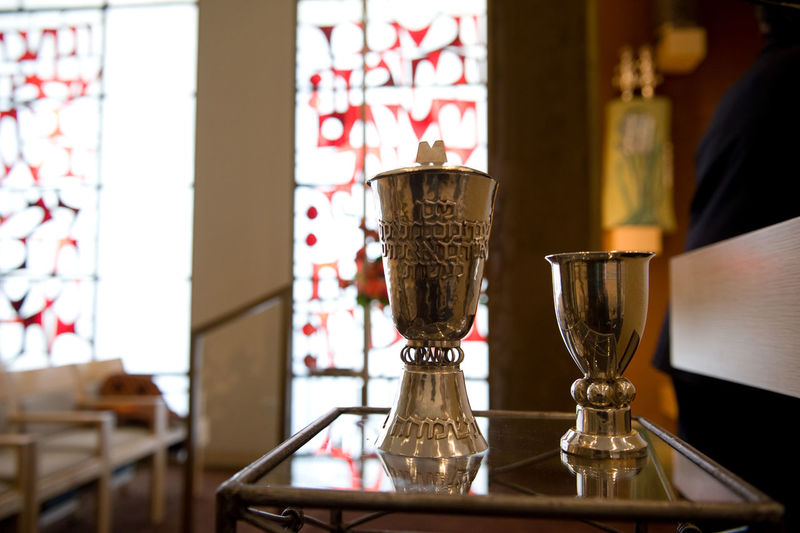 Close-up of antique chalices on glass table