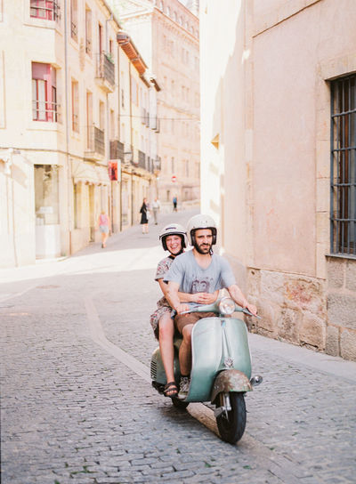 Couple riding motorcycle on street in city