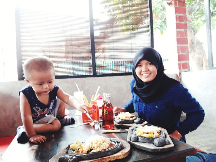 Portrait of happy woman sitting with food