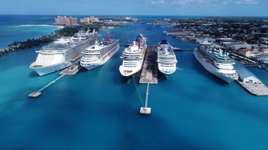 High angle view of cruise ships moored in sea against blue sky