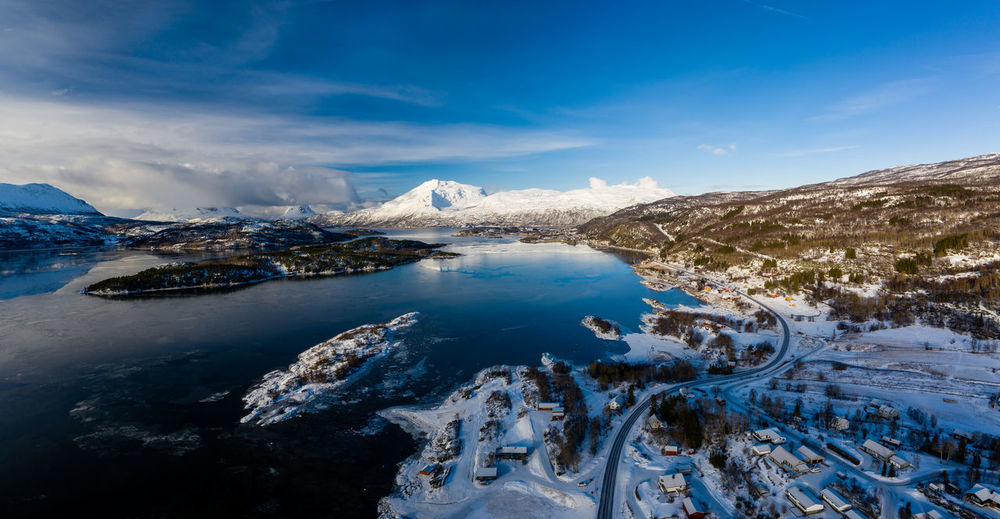 Scenic view of snowcapped mountains and lake against sky during winter