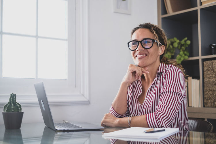 Businesswoman using laptop while sitting on table