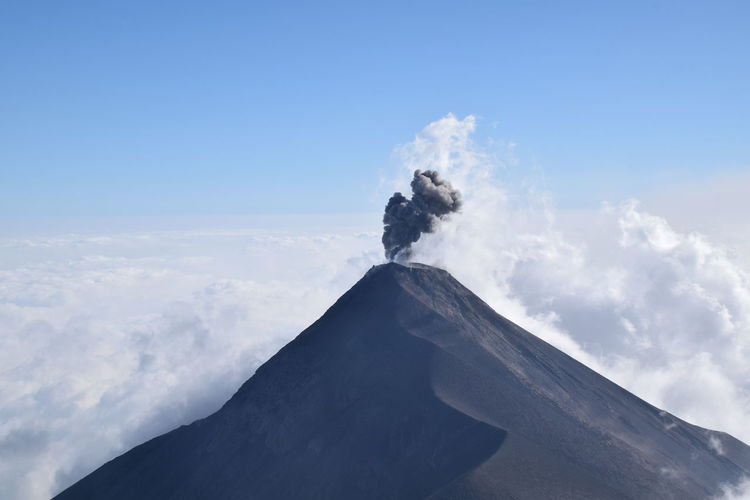 Smoke emitting from volcanic mountain against sky