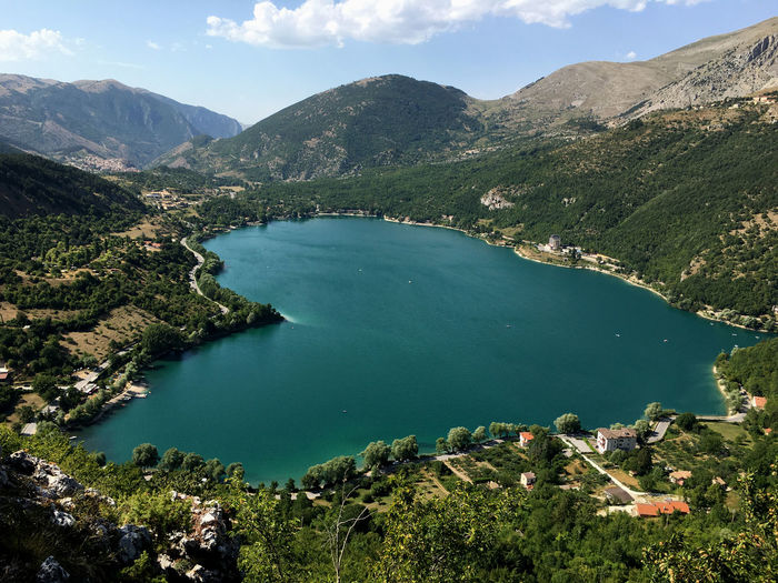 Hearth shaped scanno lake, against mountains and sky in abruzzo, italy