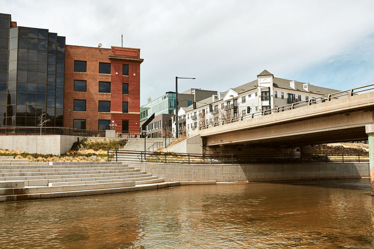 South platte river by apartments and office buildings. shoemaker plaza, confluence park. denver, co 