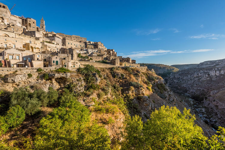Houses on mountain at sassi di matera against blue sky
