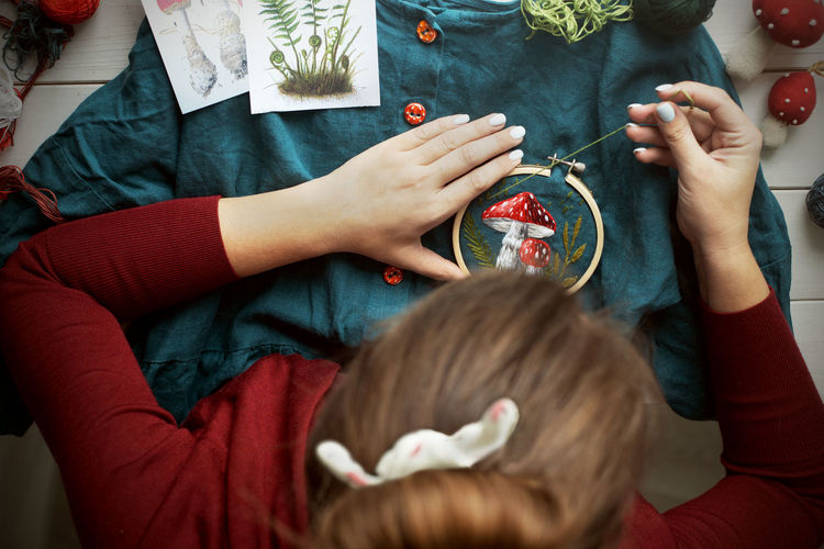 Flat lay with handmade fly agaric mushroom embroidery on dress