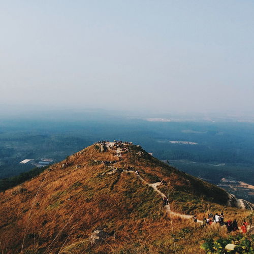 People at mountain against clear sky