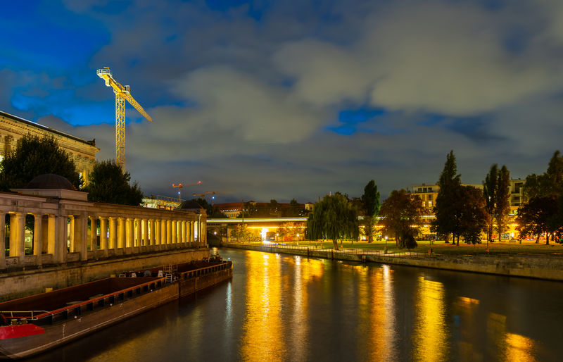 Bridge over river against sky at sunset