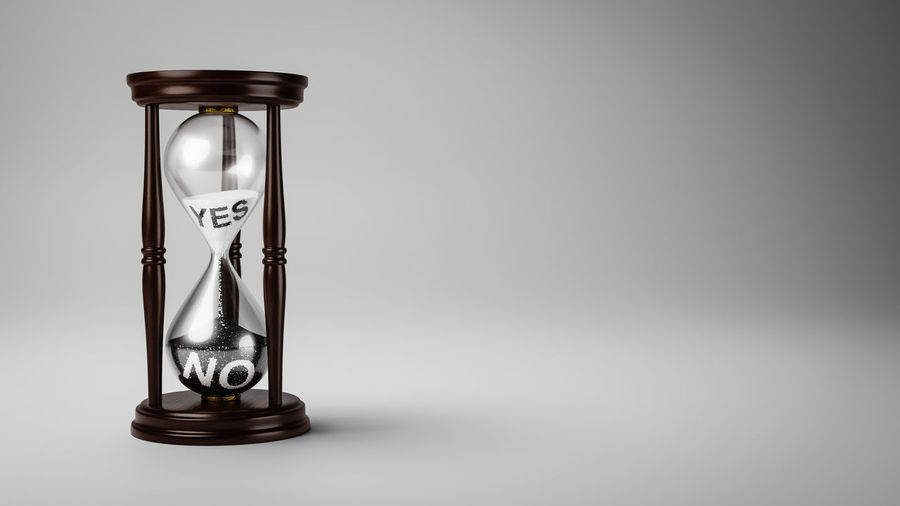 Close-up of clock on table against white background