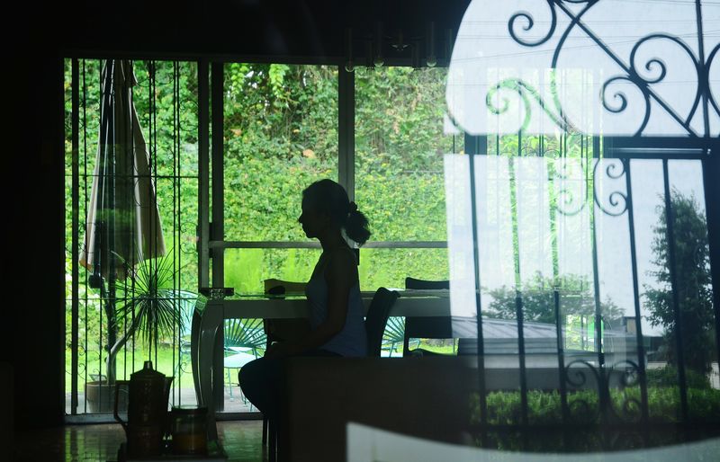 Silhouette woman standing by window