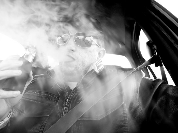 Low angle view of man smoking in car
