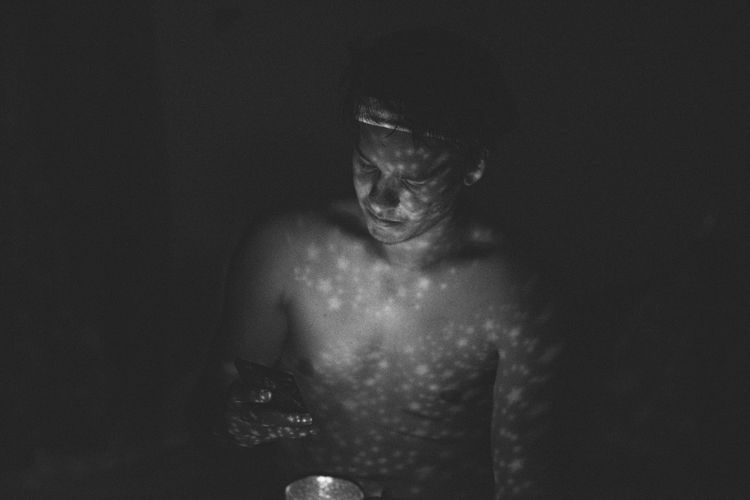 Portrait of shirtless man against black background