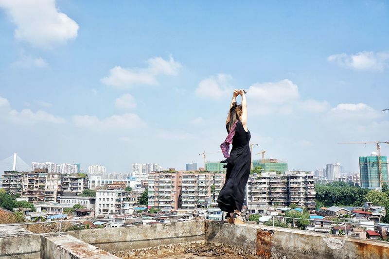 Full length of a woman with cityscape in background