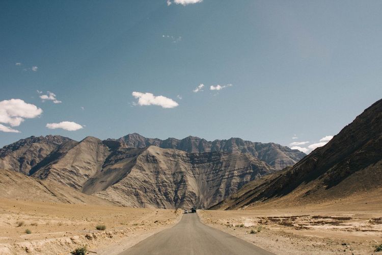 Road amidst mountains against sky