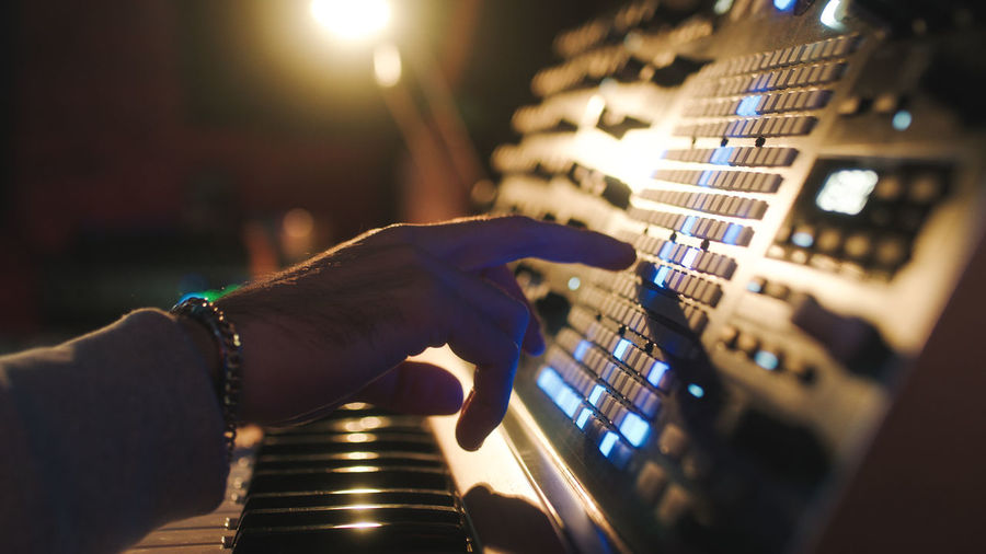 Hands of a man sound engineer are pressing buttons on the console