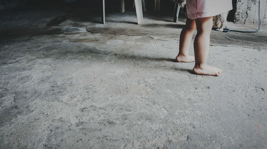 Low section of kid standing floor