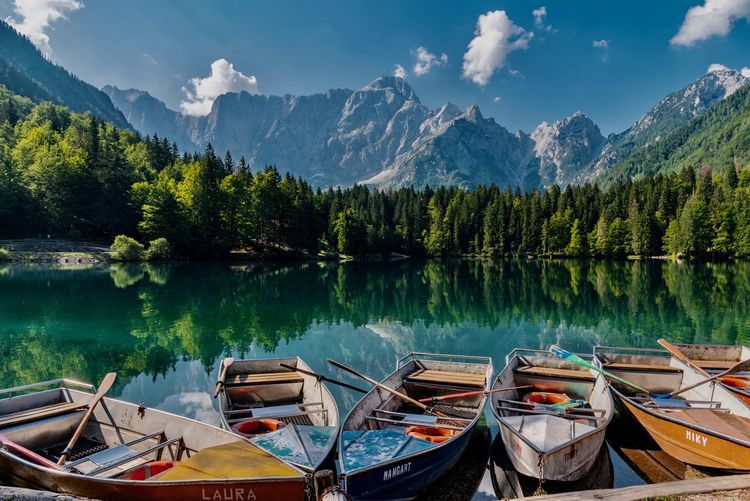 Boats moored in lake against mountains