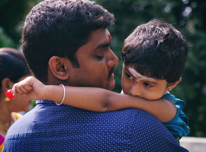 Close-up of father carrying daughter outdoors