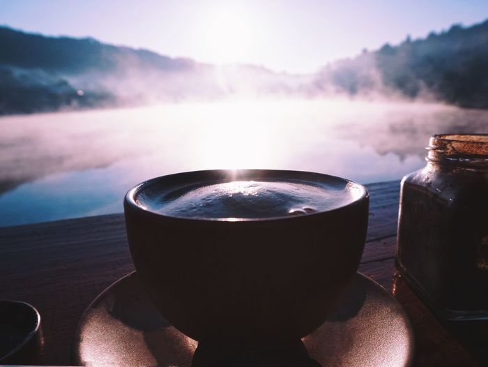 Close-up of tea cup on table against sky