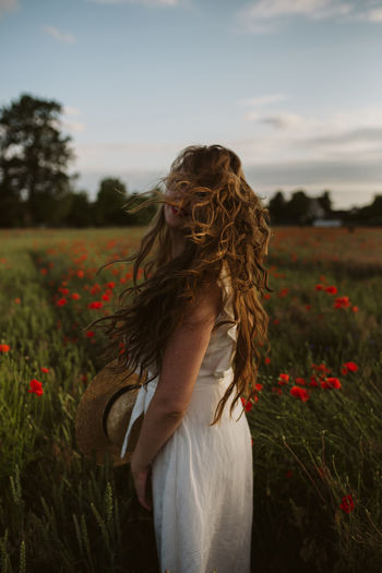 Low section of woman standing on field