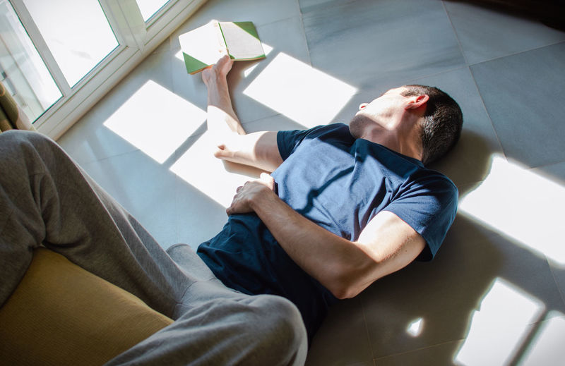 High angle view of man lying on floor at home